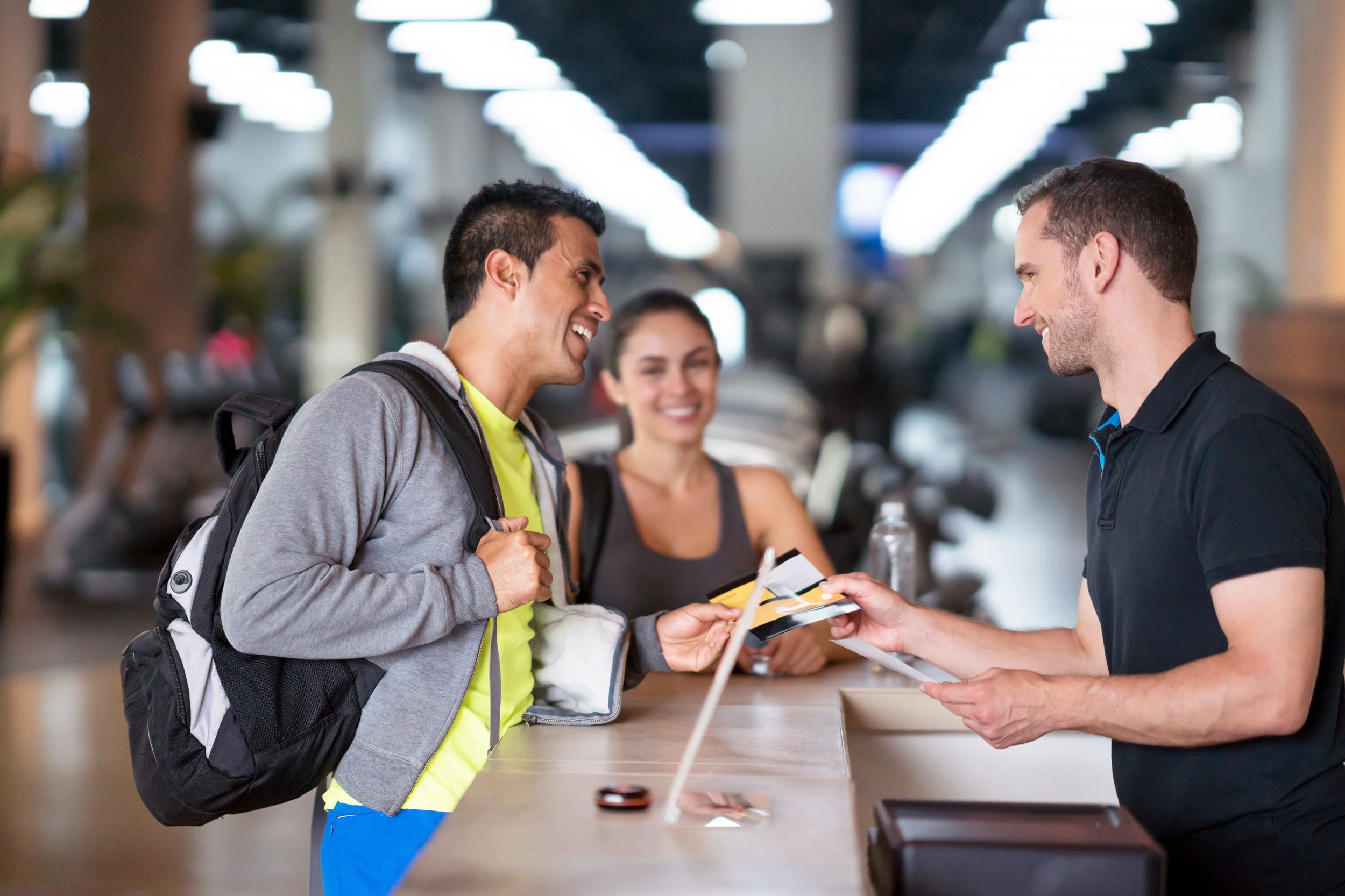 Couple talking to receptionist at the gym