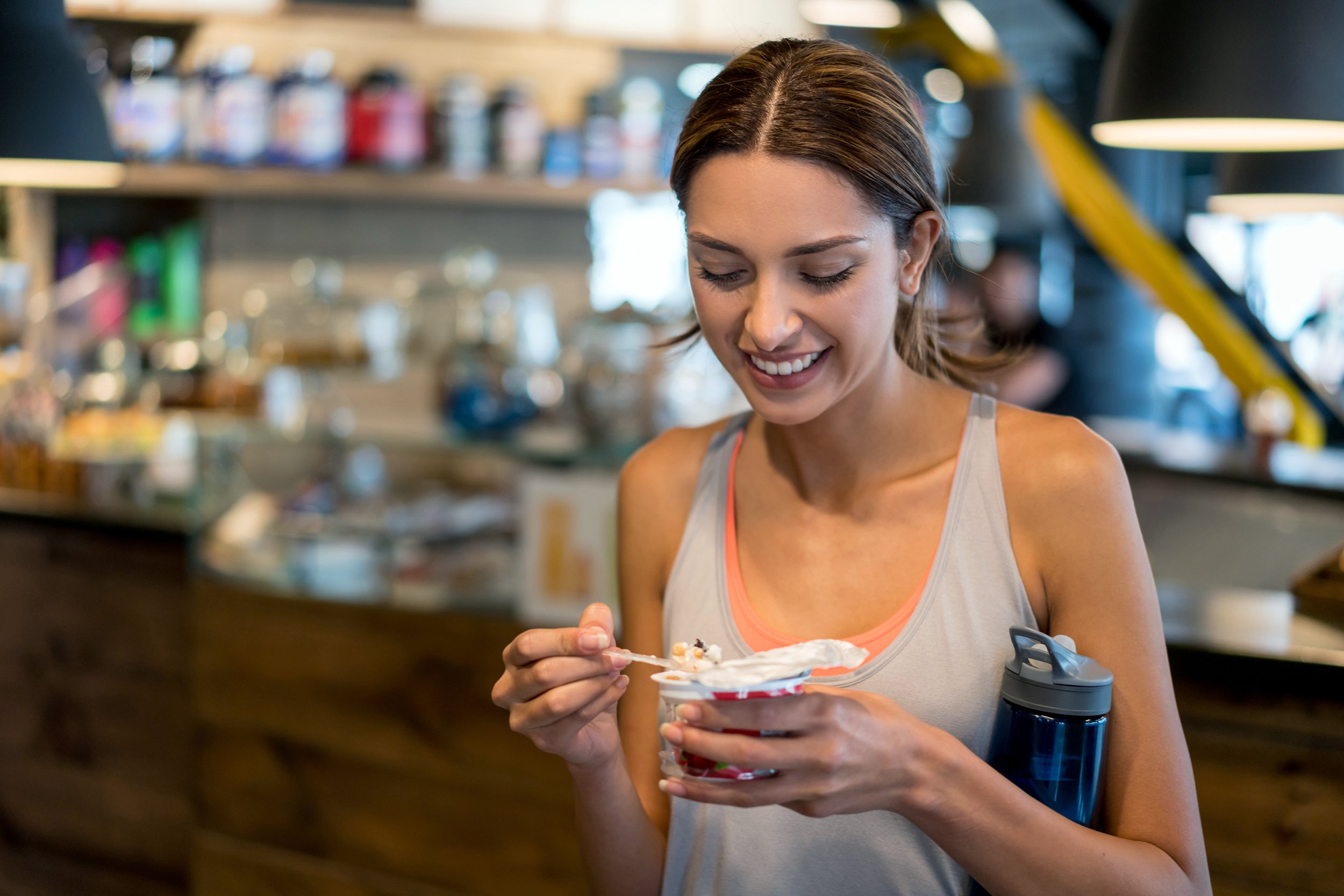 Young woman eating at the gym