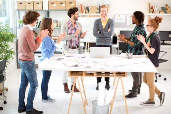 Group of young coworkers standing for a presentation