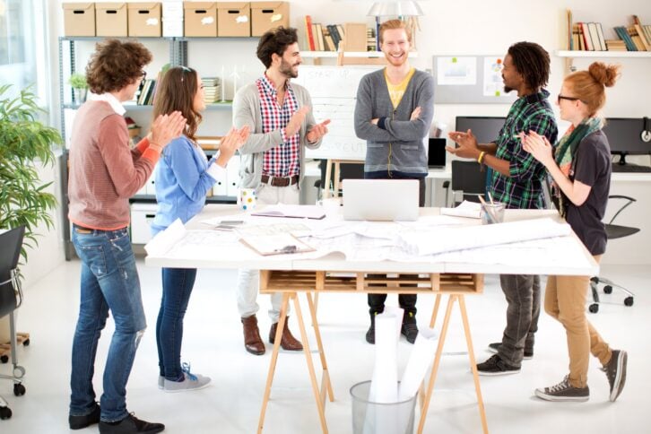 Group of young coworkers standing for a presentation