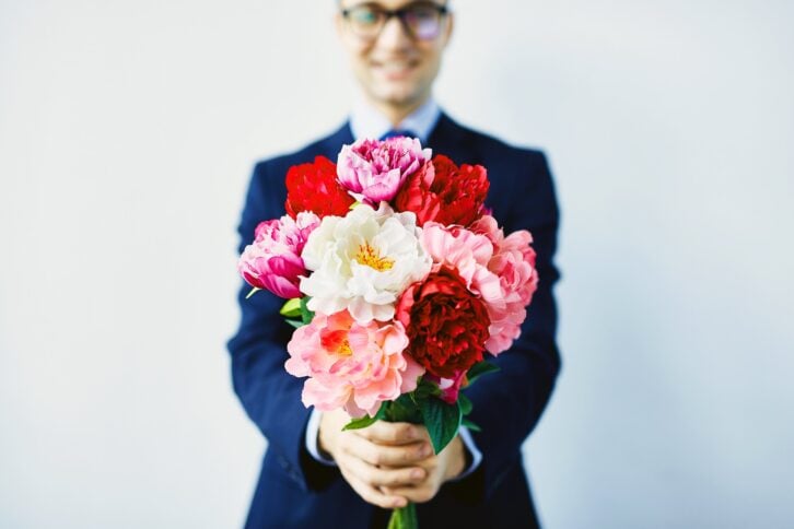 Man holding bouquet of Valentine's Day flowers
