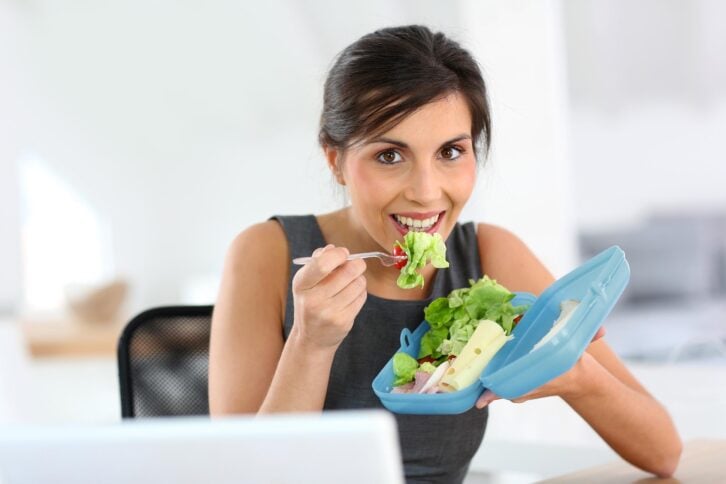 woman eating salad lunch at work