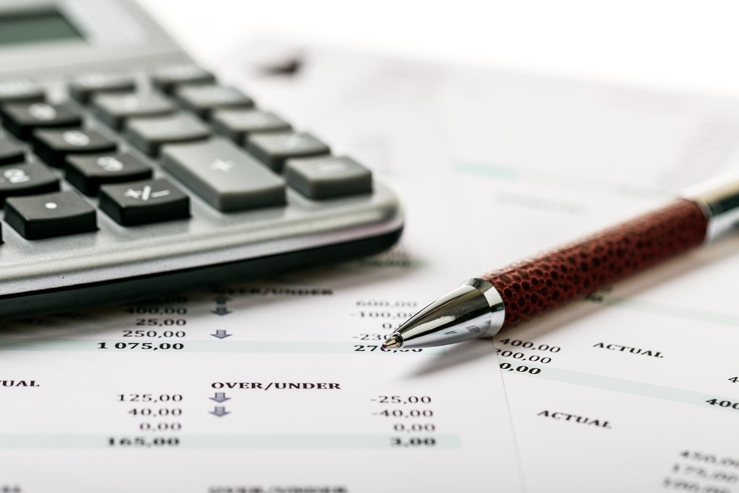 calculator and pen on bank account paper