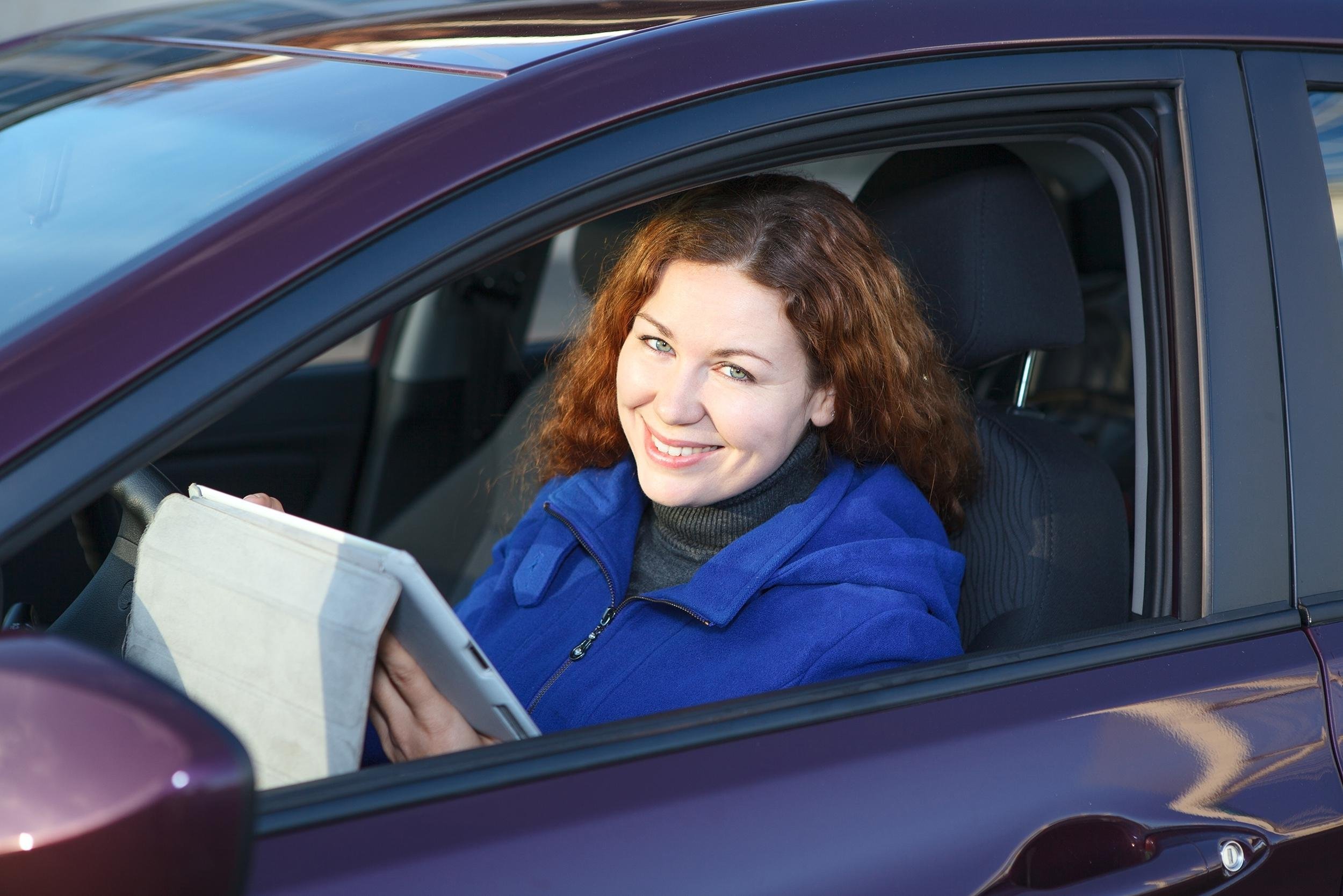 woman in car with clipboard