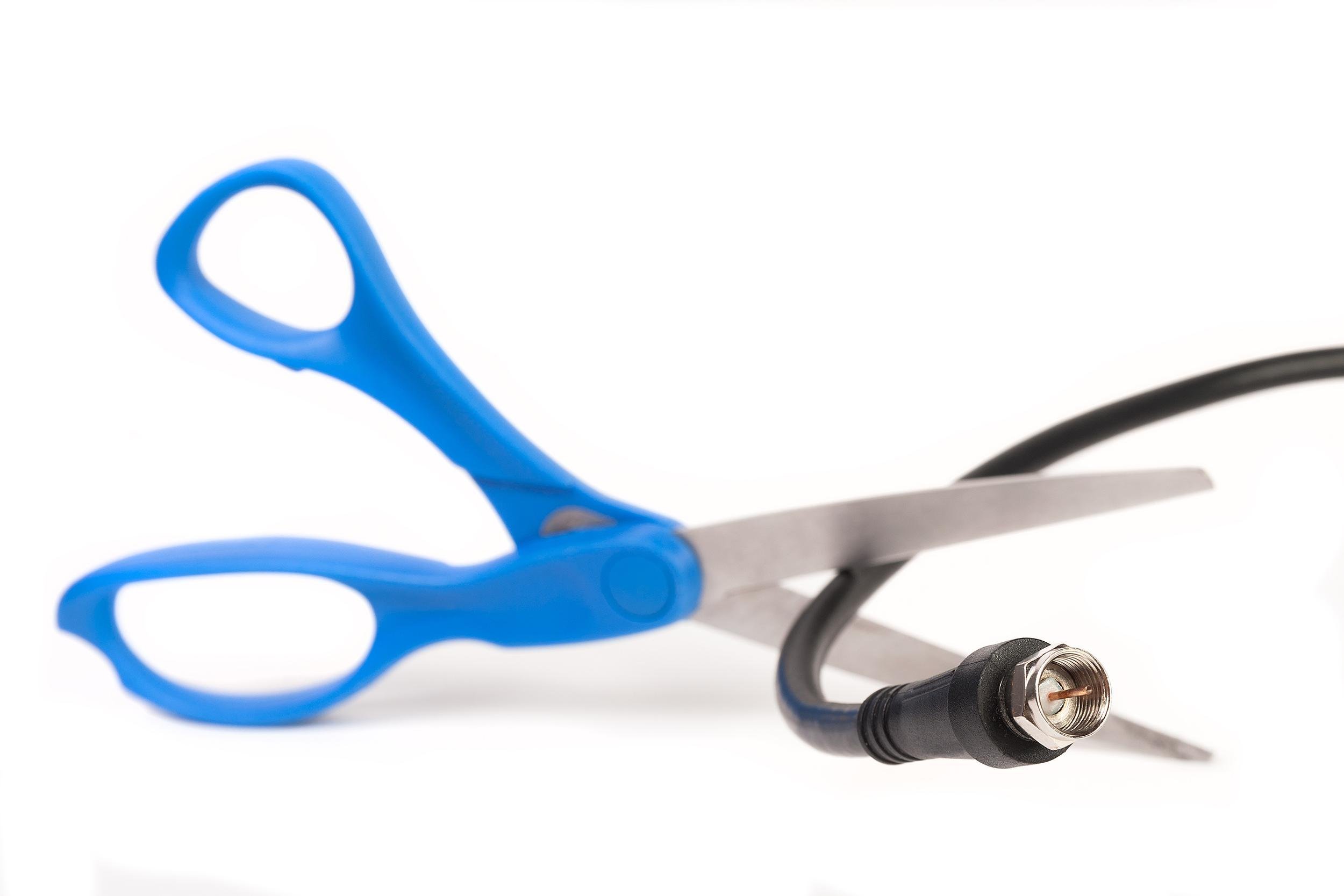 scissors cutting through a coaxial RG6 cable
