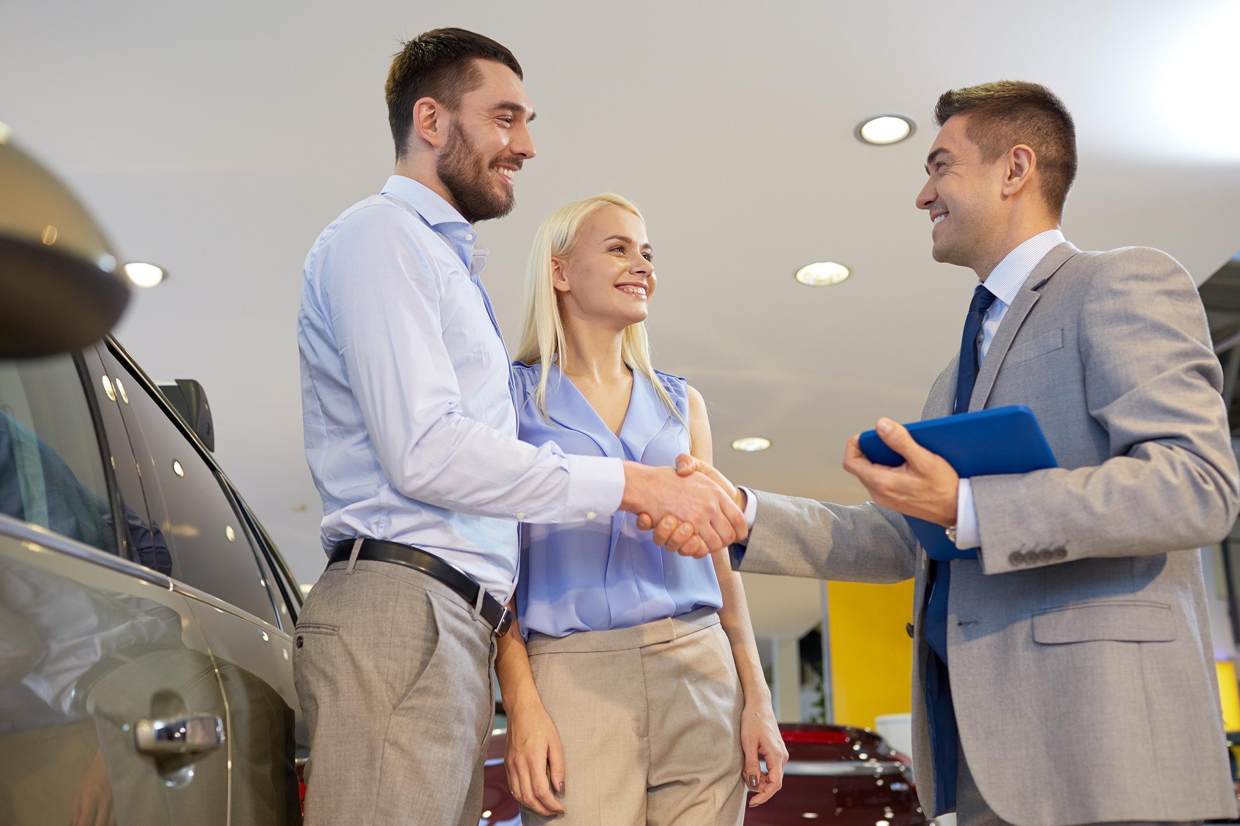 couple buying car at dealership