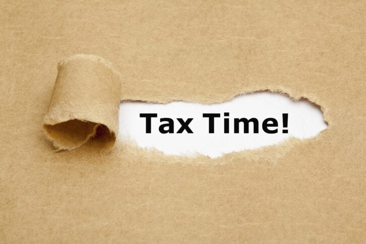 the phrase 'Tax Time' appearing behind torn brown paper