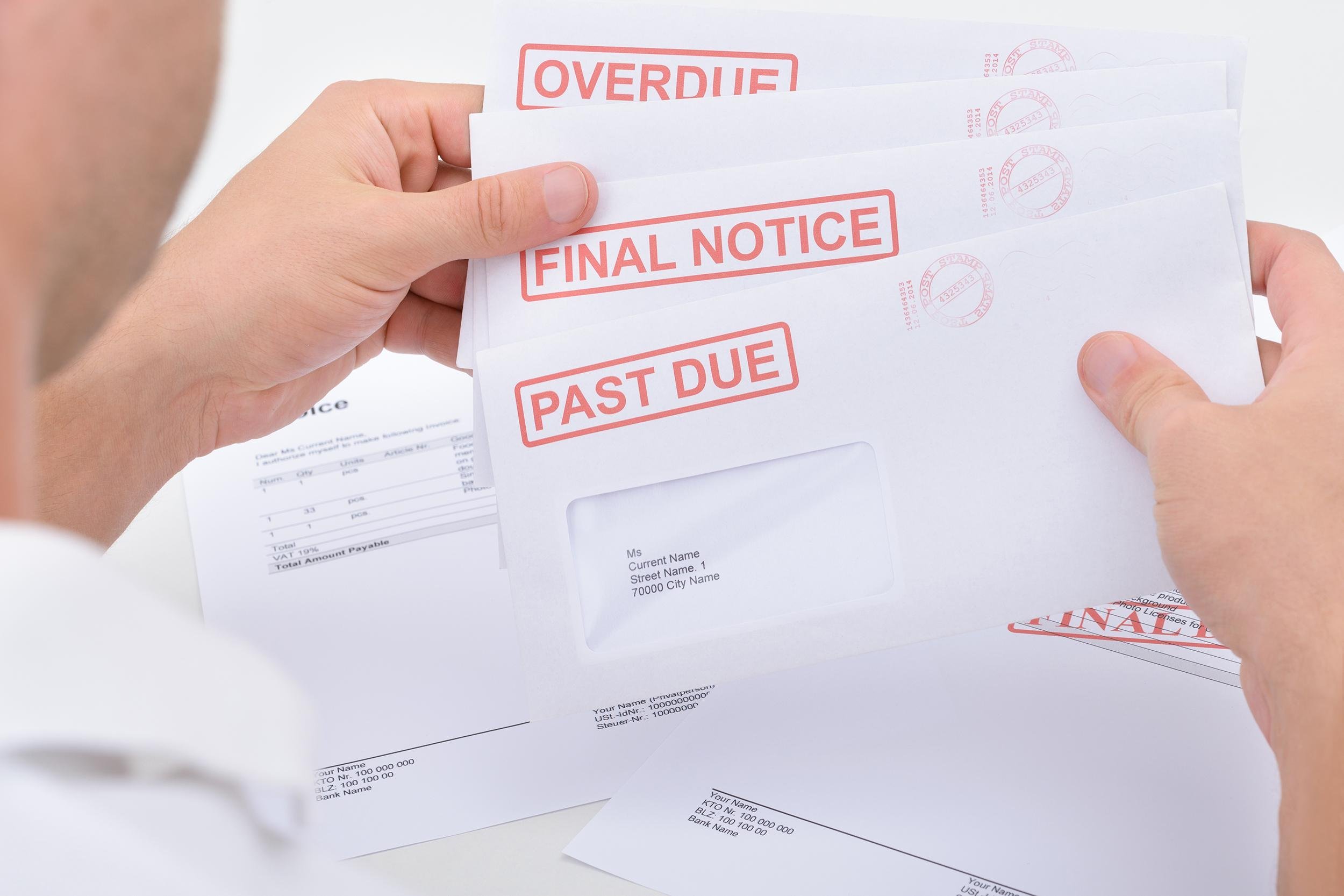 person holding past due notices