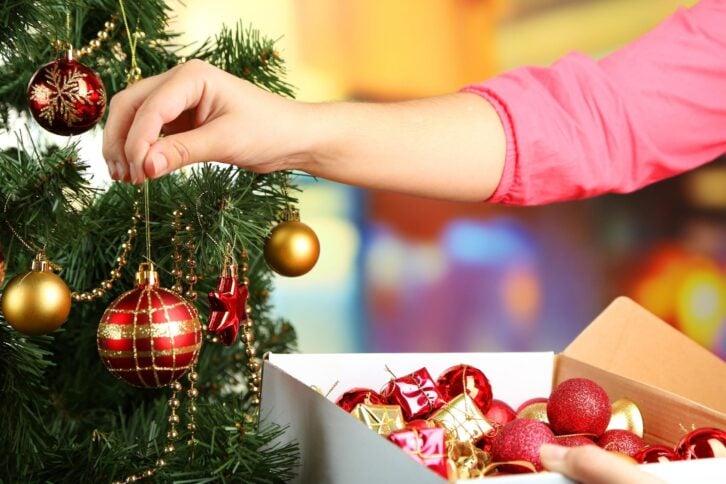 woman decorating tree with ornaments