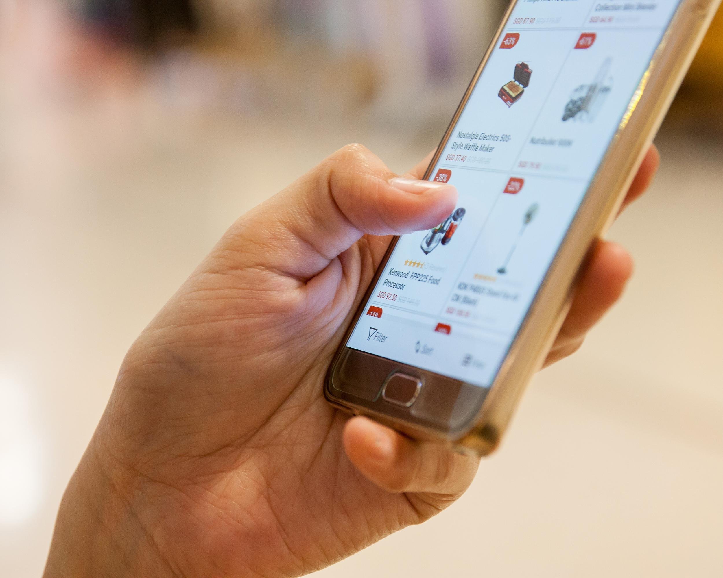 hand on smartphone comparing prices