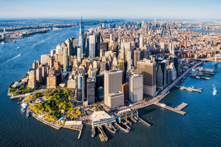 Aerial of lower Manhattan, New York, numerous skyscrapers, surrounded by a river on both sides, on a clear, sunny day