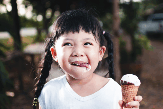 Happy little girl eating an ice cream cone