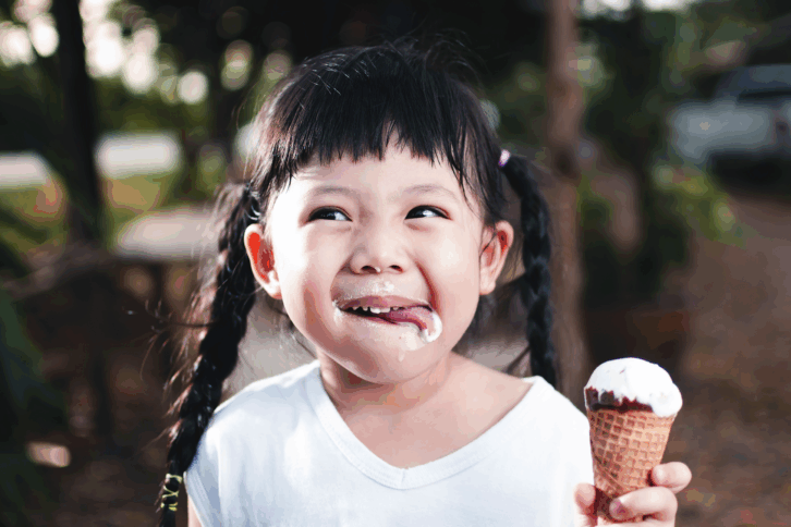 Happy little girl eating an ice cream cone