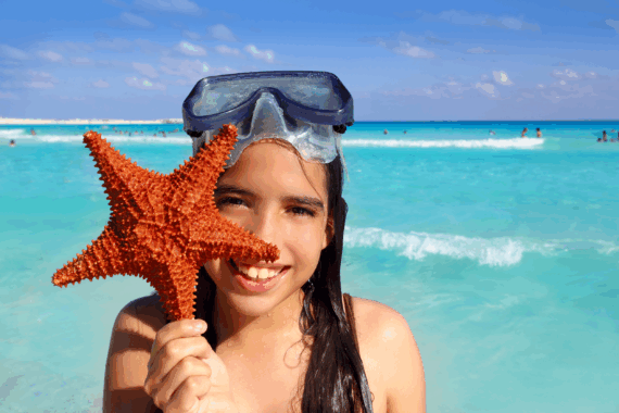Young girl in Mexico holding a starfish