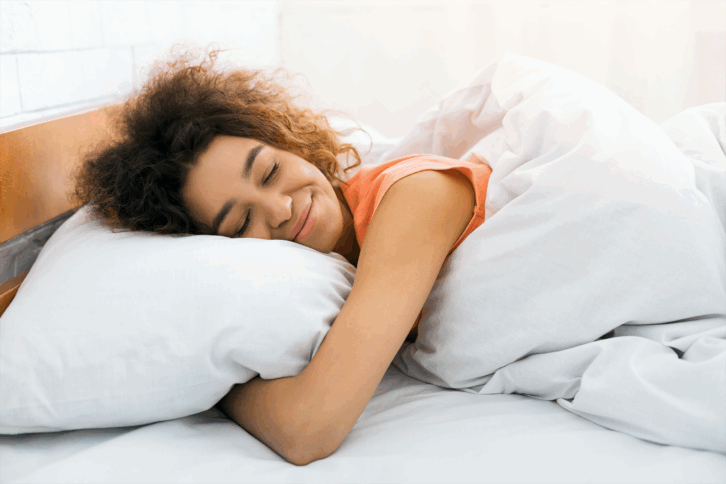 woman sleeping happily on pillow