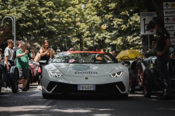 People taking photos of a white ferrari on a street
