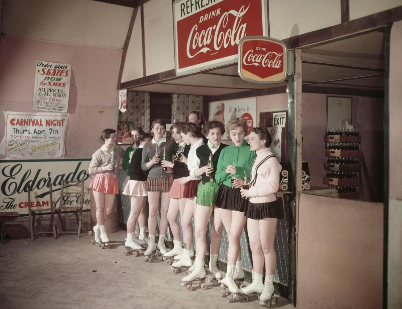 A group of women at the roller skate rink in the 1950s having a Coca-Cola break.