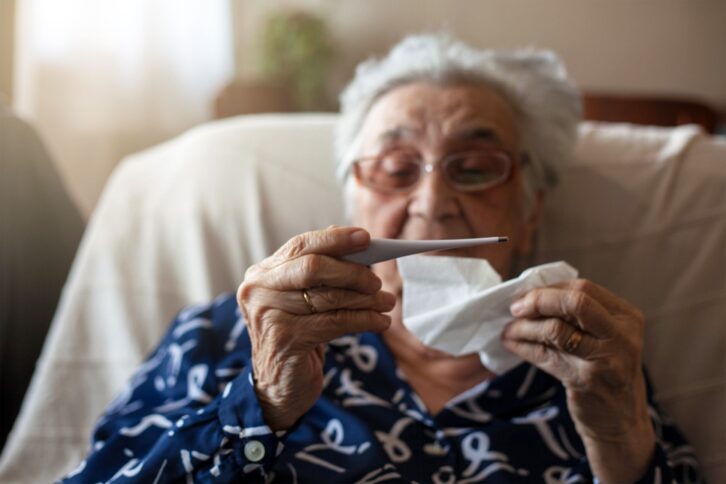 Senior woman taking her temperature