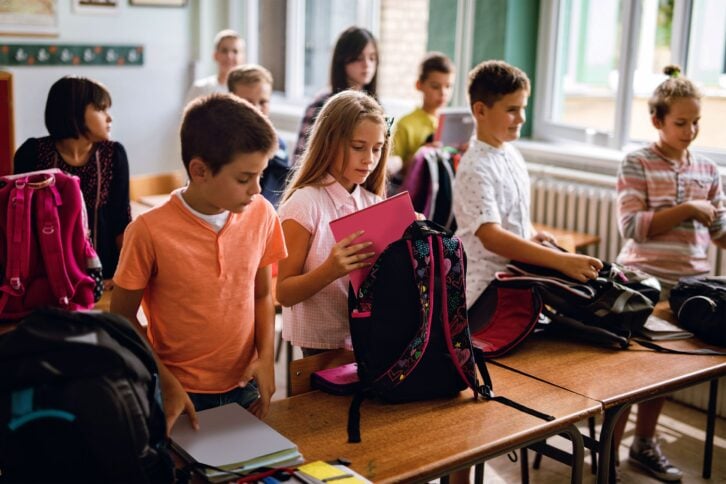 Kids packing their backpacks after class