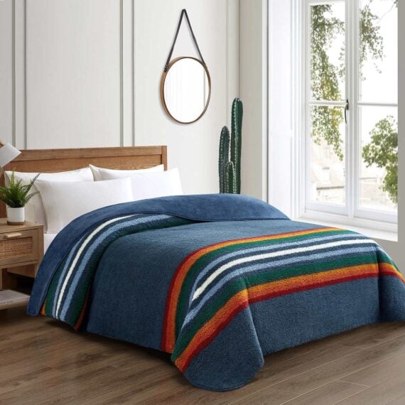 Bedroom displaying blue Pendleton-brand plush blanket on bed