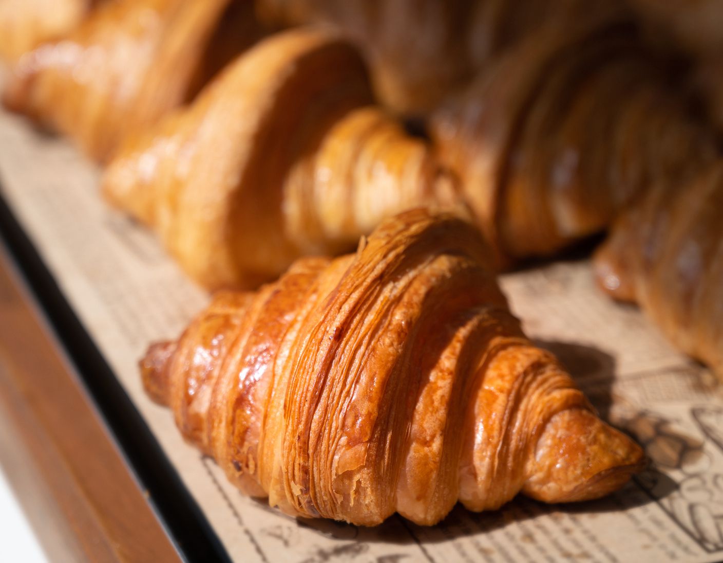 Freshly baked croissants, golden brown on paper, ready to serve in the morning.