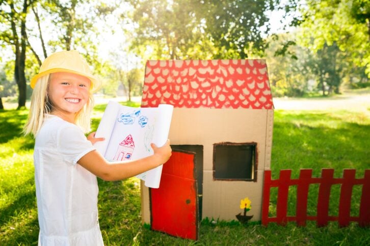 Little girl building a fort outside