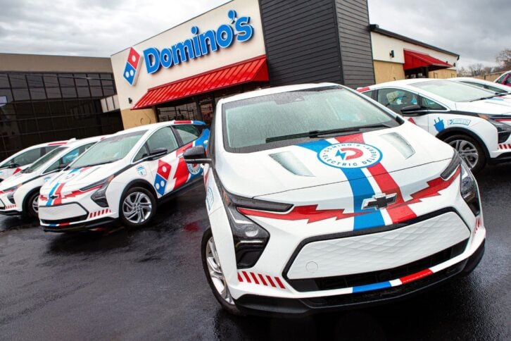 A Chevrolet Bolt electrical vehicle decorated with Domino's logos