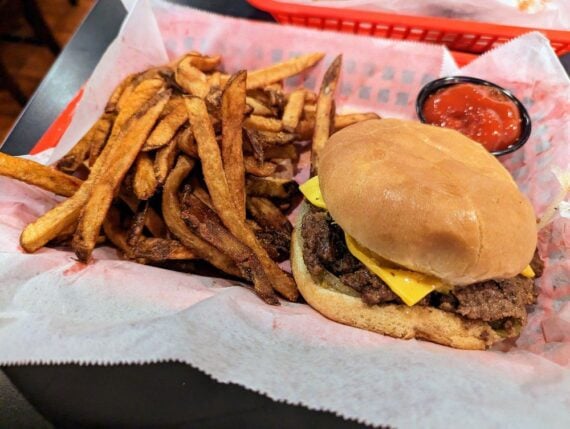 A deep-fried burger with cheese, pickles, onions and mustard with a side of fries and ketchup from Dyer's Diner in Memphis, Tennessee.
