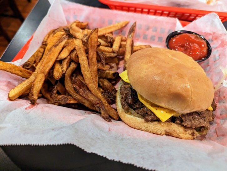 A deep-fried burger with cheese, pickles, onions and mustard with a side of fries and ketchup from Dyer's Diner in Memphis, Tennessee.
