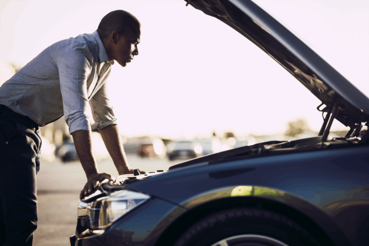 Man looking under hood of car