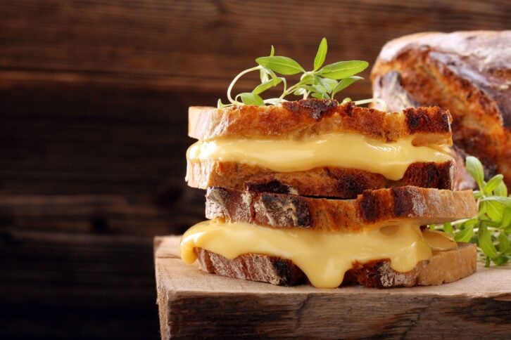 Grilled cheese sandwich on rustic bread with fresh herbs