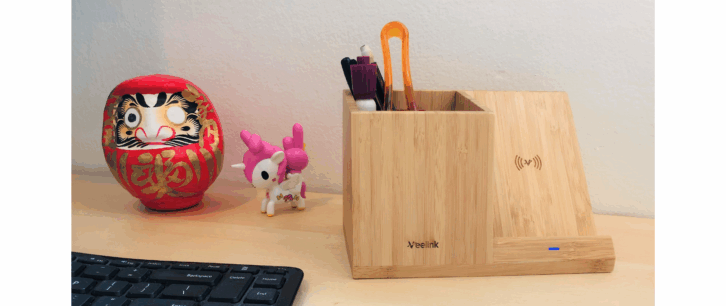 Veelink bamboo wireless charger and organizer on a desk next to desk decorations and a keyboard