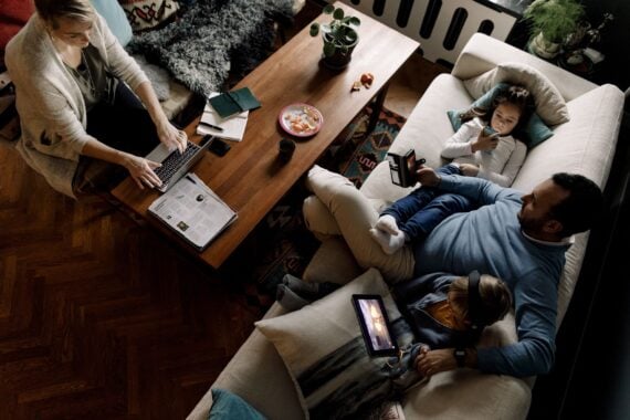 high angle view of family using various technologies in living room at home, in low light
