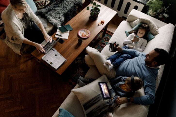 high angle view of family using various technologies in living room at home, in low light