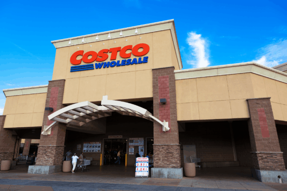 Front exterior of Costco Wholesale, Citrus Heights, California, people entering through doors on a sunny day, a blue sky in the background