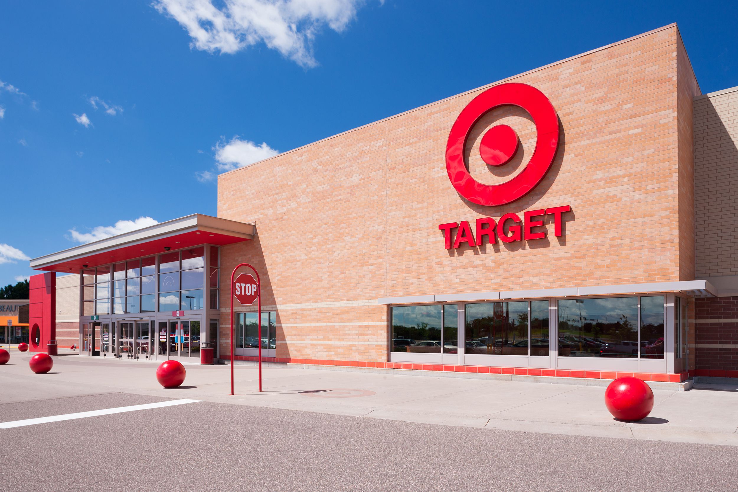 Front exterior of Target, Minnetonka, Minnesota, with a large sidewalk and drive-through road in the foreground, clean, on a sunny day with a blue expansive sky