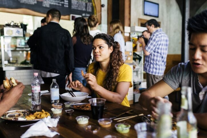 young friends eating at fast-casual restaurant