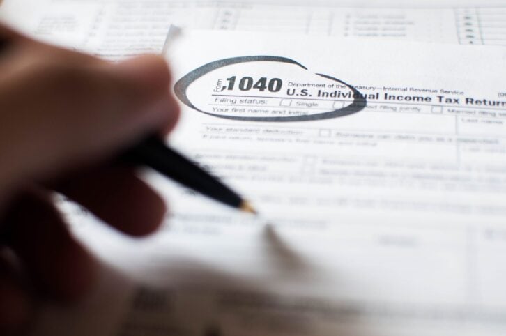 close-up of a young person writing on a tax document
