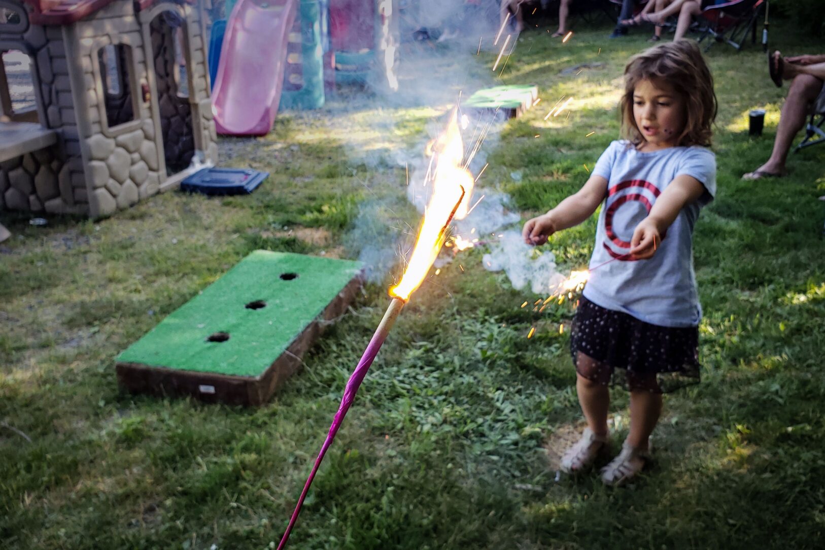 little girl with sparklers at party in yard