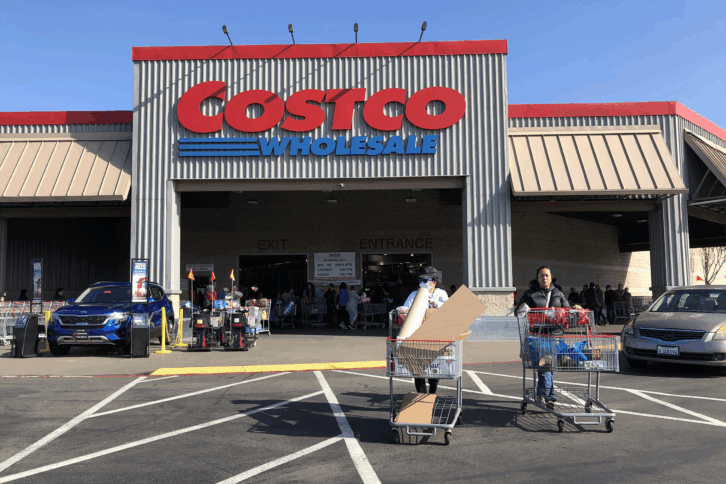 Costco customers push shopping carts through the parking lot of a Costco store on March 13, 2020 in Richmond, California.