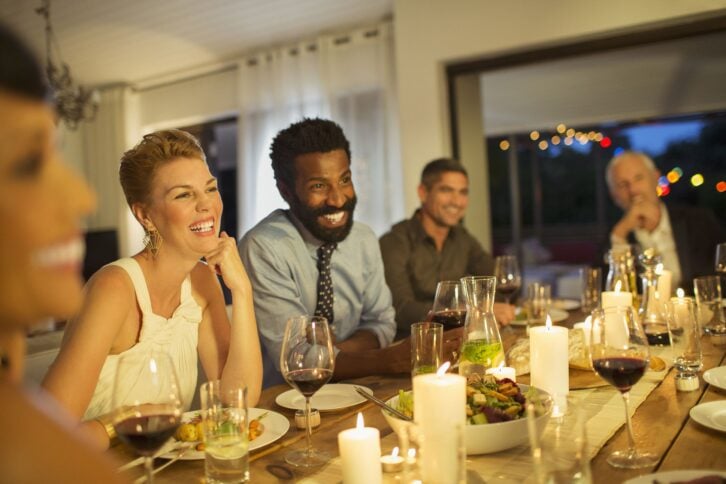 friends laughing at dinner party