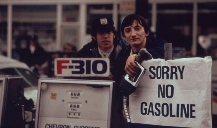 Gas station attendants peer over their "Out of gas" sign in Portland, on day before the state's requested Saturday closure of gasoline stations. Image courtesy national archives, united states, 1973.