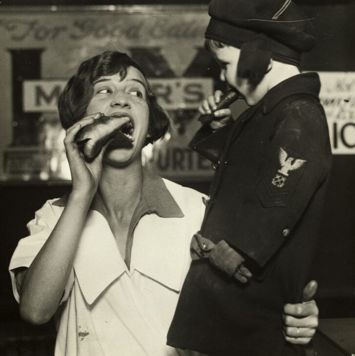 A woman and child enjoying hot dogs in 1926