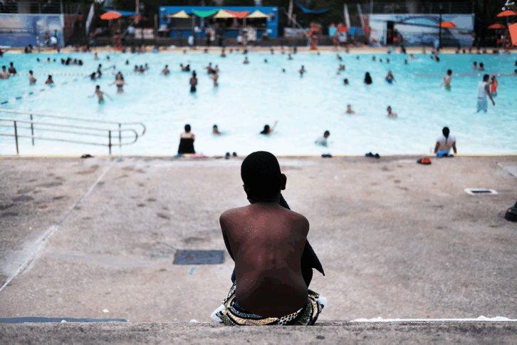 A child takes a break from swimming on a hot afternoon at the Astoria Pool