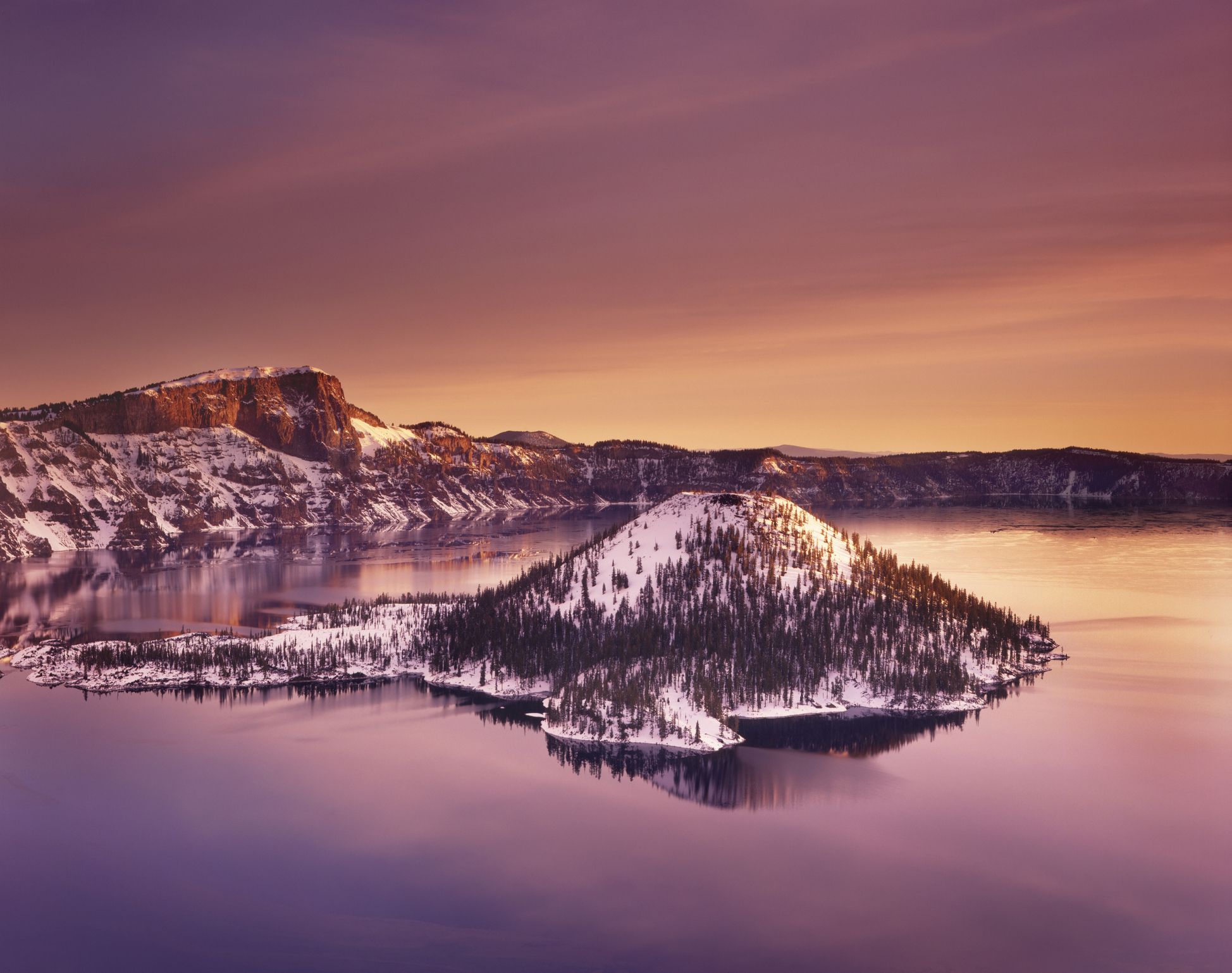 Winter dawn over Crater Lake and Wizard Island, Crater Lake National Park, Oregon USA.