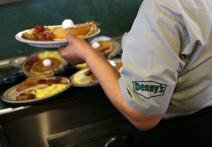 Denny's staff handling plates of breakfast foods
