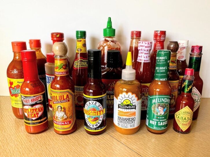 Group of 20 Popular Hot Sauces on Table