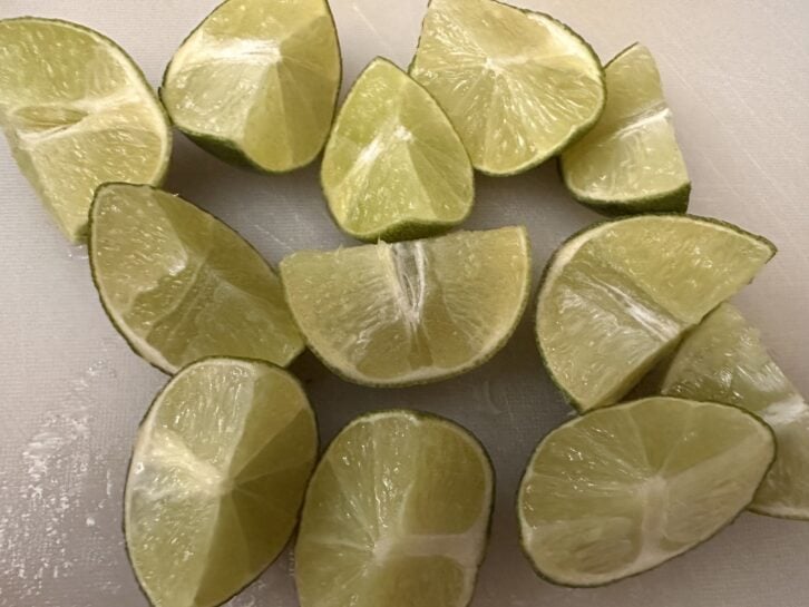 quartered limes on cutting board