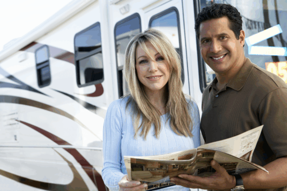 Couple looking at a brochure interested in renting or purchasing an RV