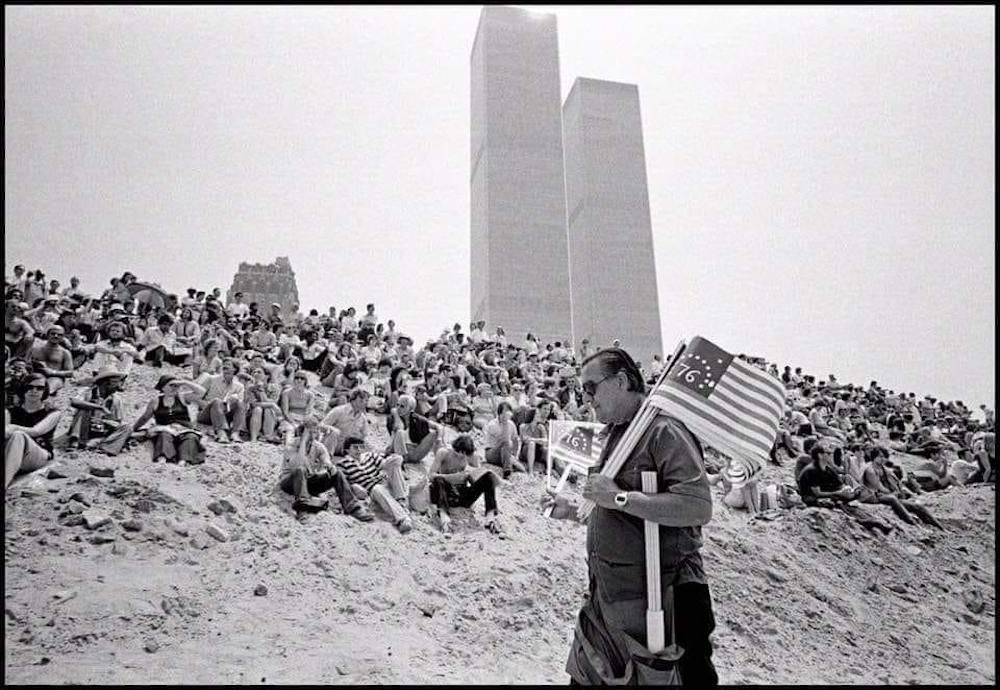 July 4, 1976! Crowds gather to watch Op Sail with twin towers in background. Two hundred giant sailing ships entered the harbor. Gillies Peress, photographer.